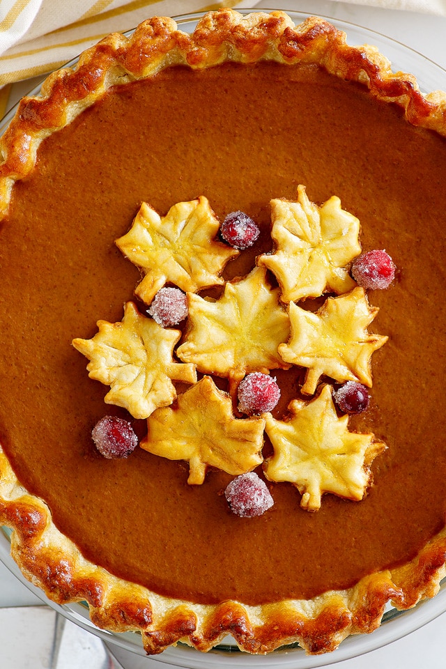 Top down photo of pumpkin pie with flaky and golden brown pie crust. 