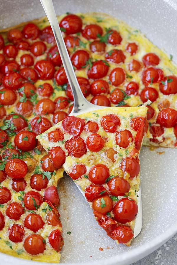 A slice of delicious cherry tomato frittata in a skillet.