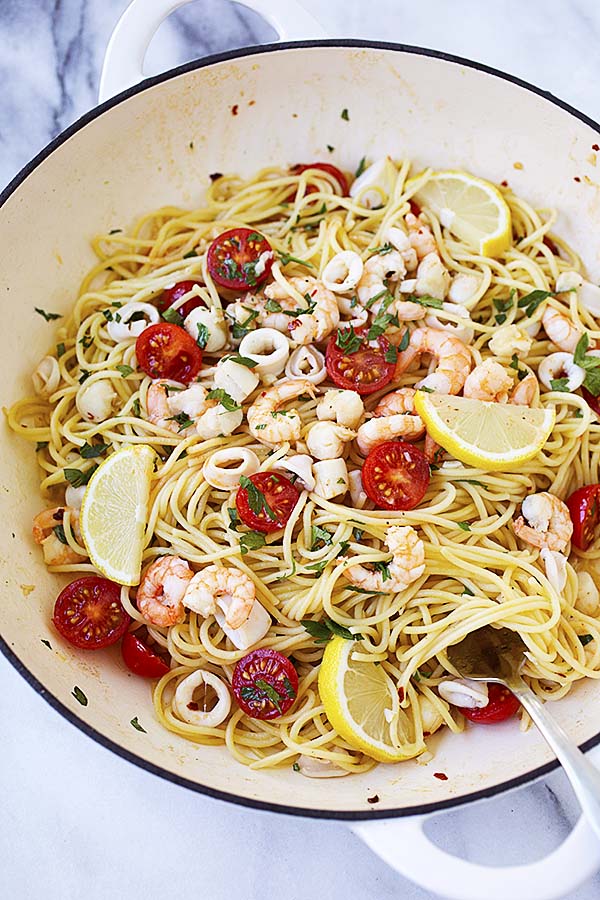 Seafood scampi in a white skillet.