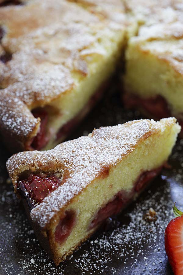 A slice of homemade delicious strawberry cake topped with powdered sugar.