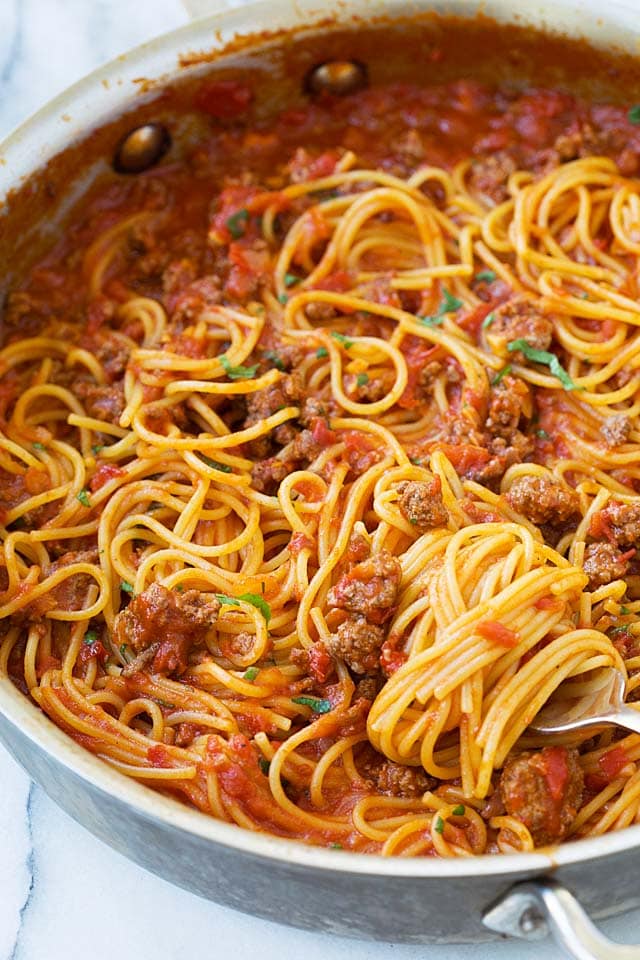 Close up picture of easy spaghetti pasta with orange-color tomato meat sauce, ready to be eaten.