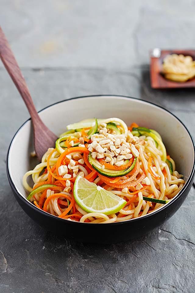 Easy and quick Thai Peanut Zucchini Noodles with carrots and peanut sauce, topped with crushed peanuts. 