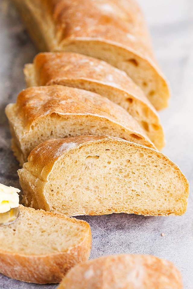 Close up of baguette, with golden brown crusty exterior and soft white interior.