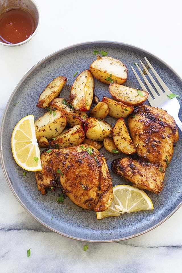 Chicken and potatoes on a plate with a fork, ready to serve.