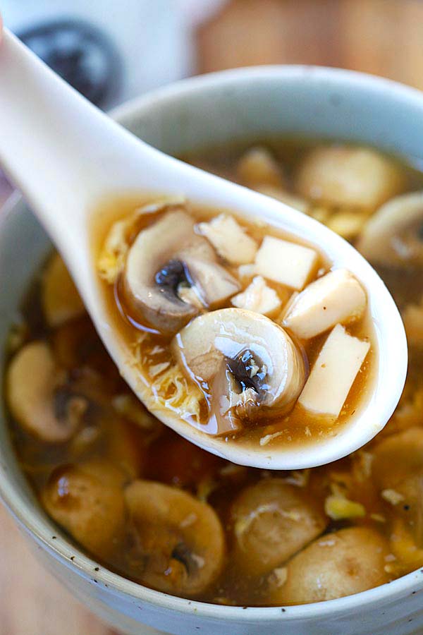 Hot and sour soup with mushrooms and eggs on a spoon. 