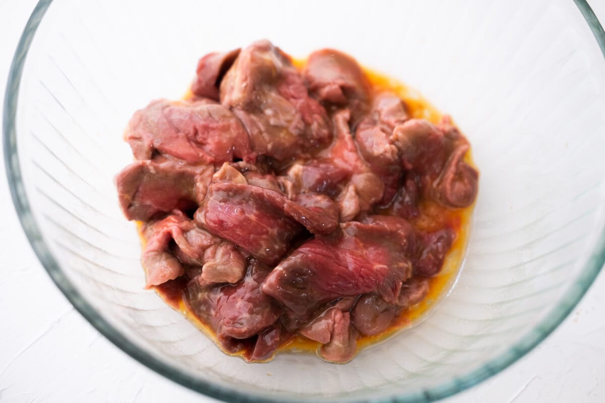 Marinating the beef with the marinade in a bowl. 