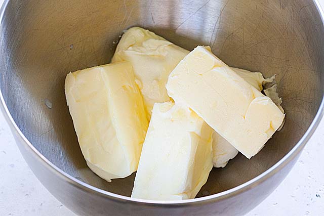 Butter and cream cheese in a a bowl of a stand mixer.