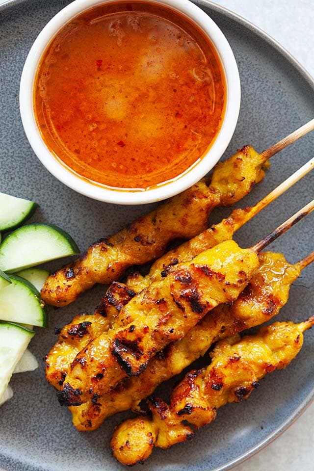 Perfectly grilled and charred chicken satay dish with satay peanut sauce. 