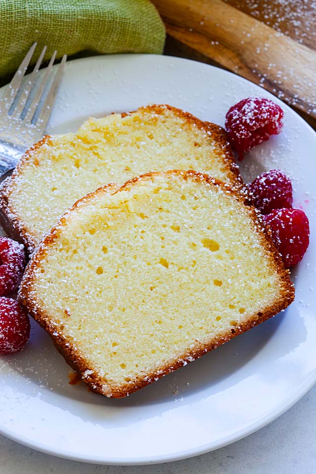 Two pieces of cream cheese pound cake on a plate with dessert fork, ready to be served.