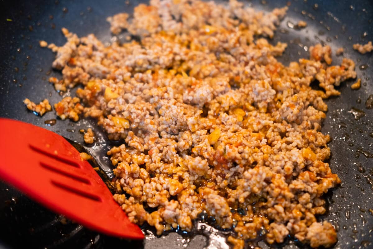 Cooking mapo tofu and ground pork in a wok. 