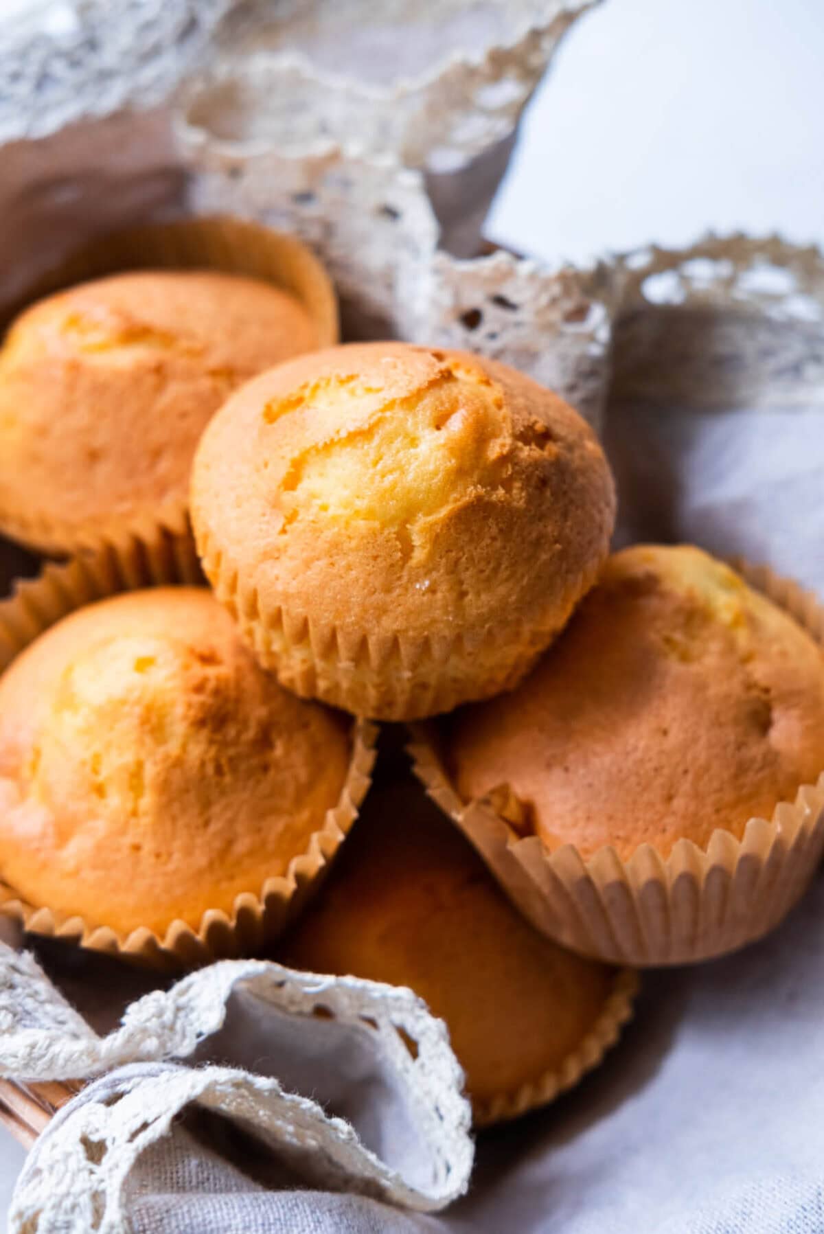 Golden and yellow mini egg cup cakes in a serving basket. 