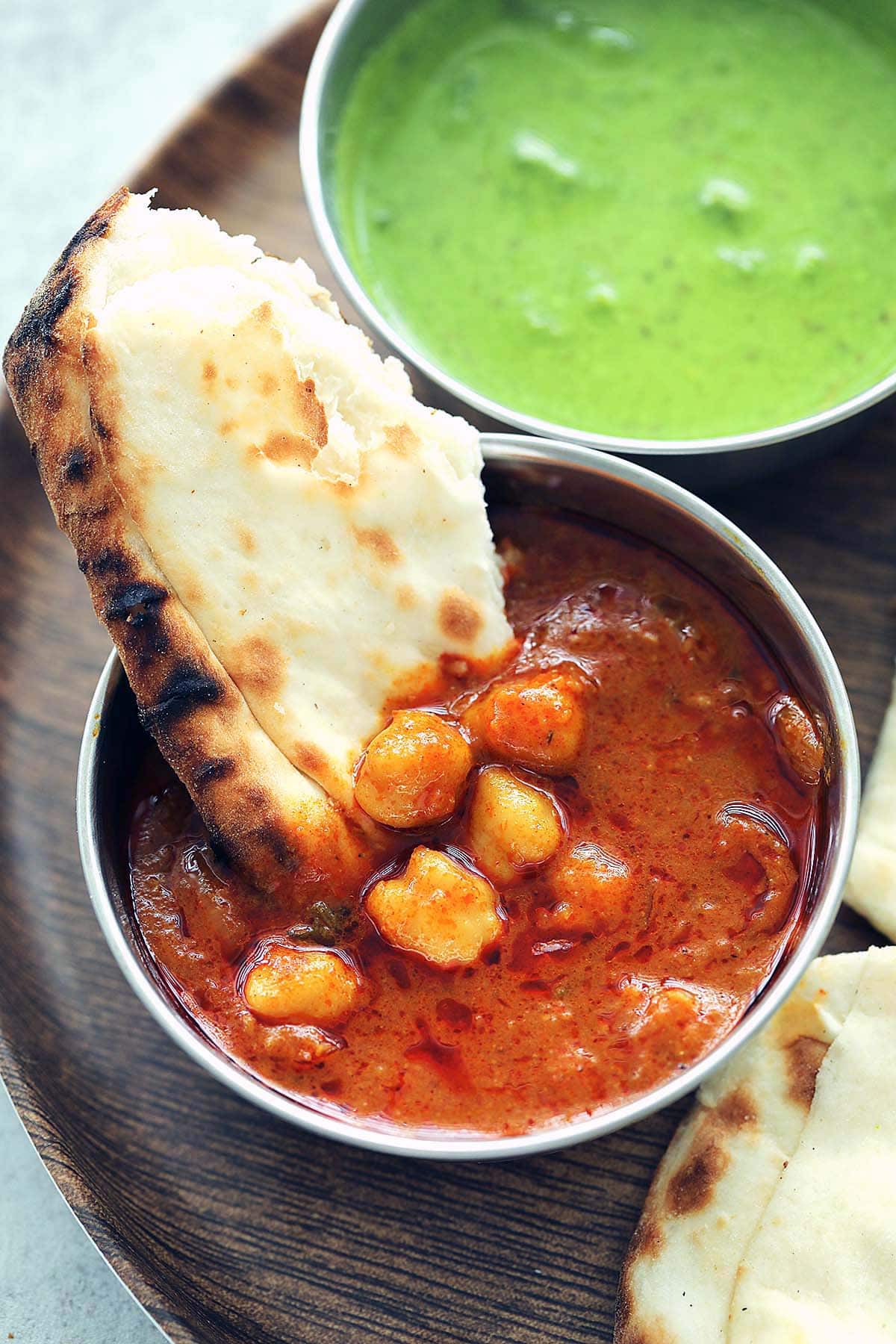 Hand-torn piece of garlic naan dipped in chana masa. 