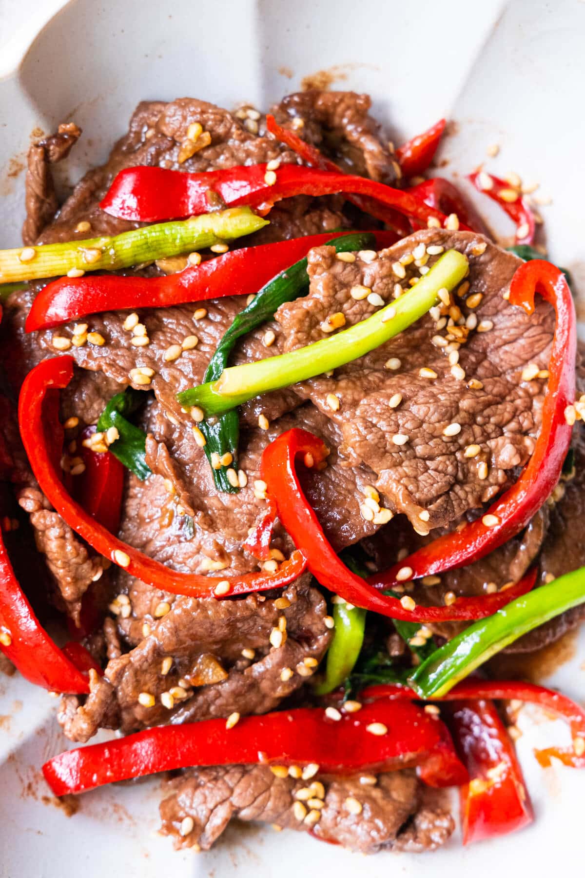 Asian stir-dry sesame beef in brown sauce in a bowl.