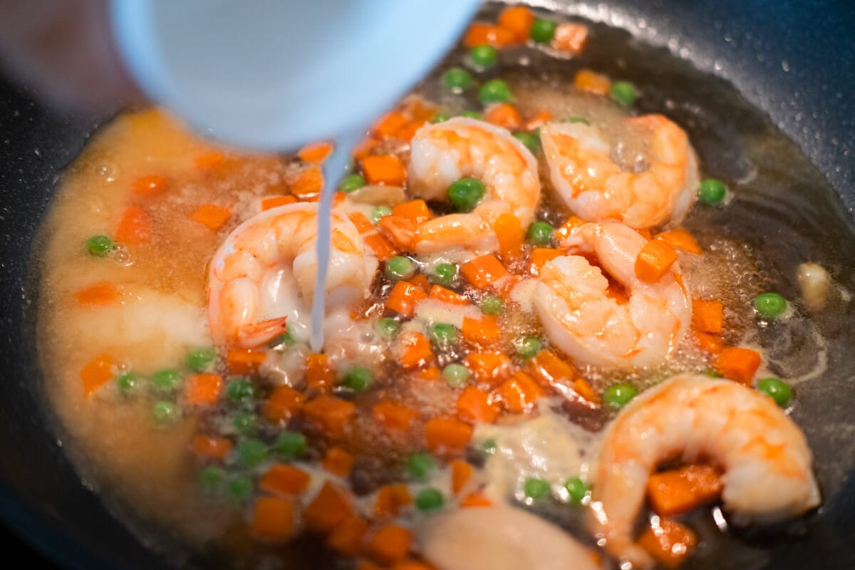 Adding cornstarch mixture to the shrimp. 