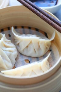 Steamed dumplings in a bamboo steamer.