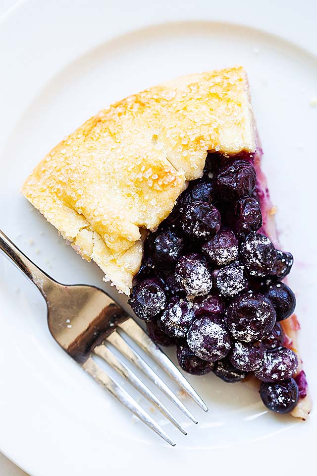 Blueberry galette on a white plate with a fork.