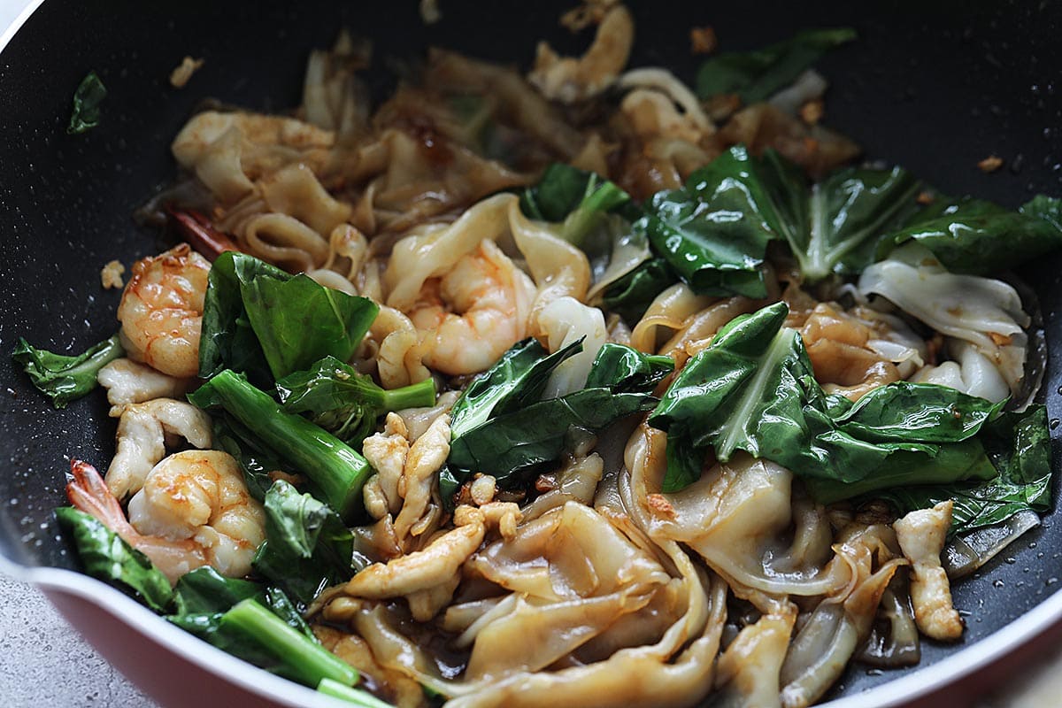 Cooking pad see ew noodles with sauce in a skillet. 