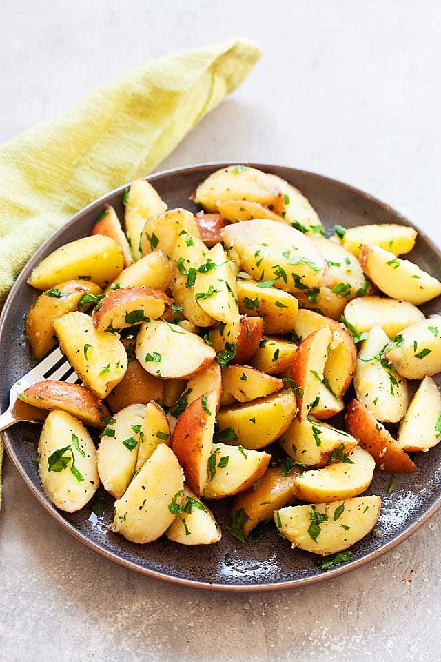 A plate of boiled potatoes with fork.