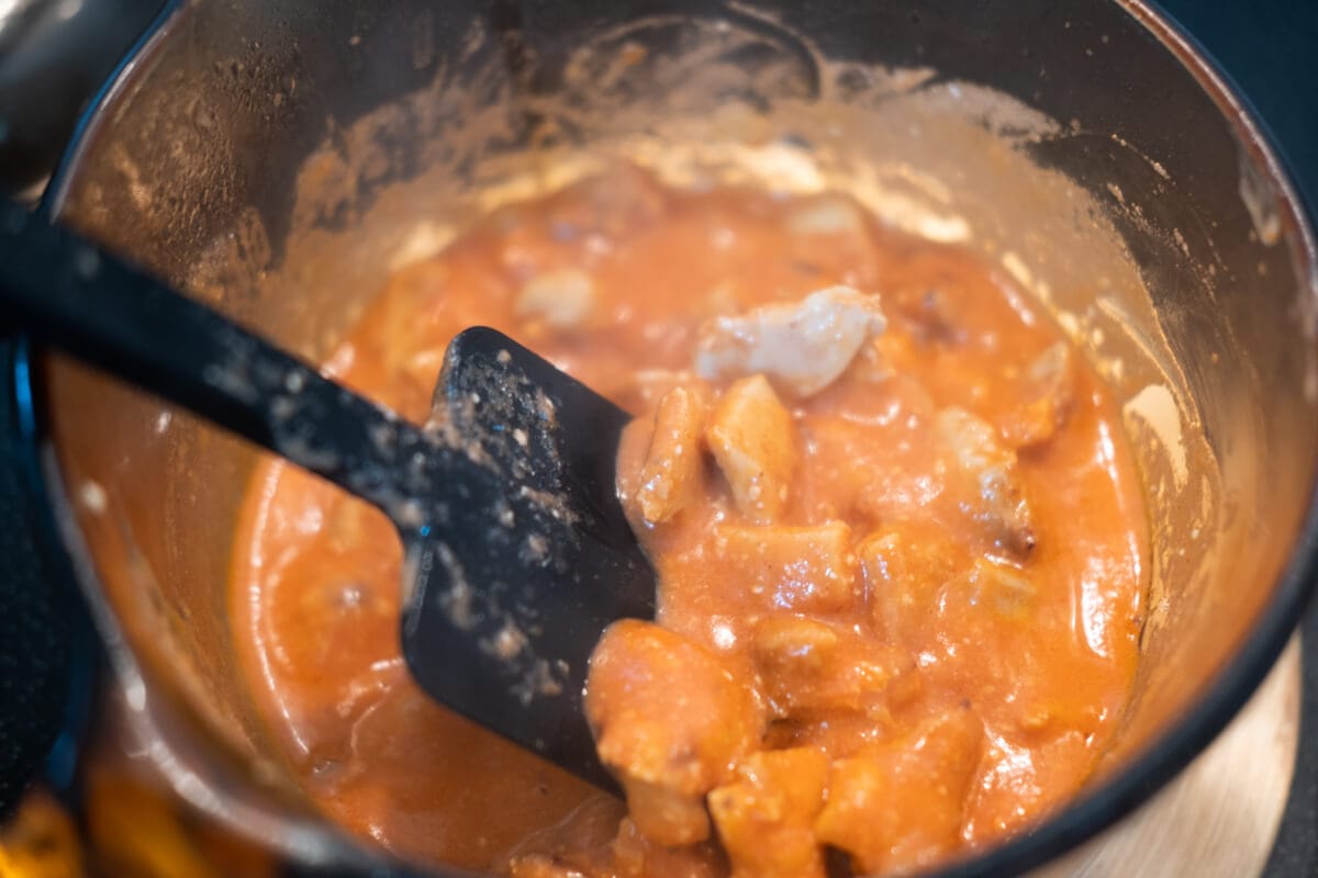 Grilled chicken cubes with tikka masala sauce sauce in a sauce pan. 