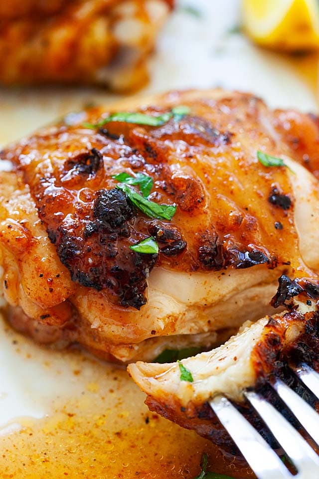 BBQ chicken thigh with a fork, with juicy oozing out.