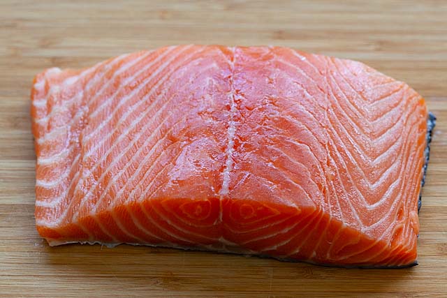 Salmon second cut on a bamboo cutting board.