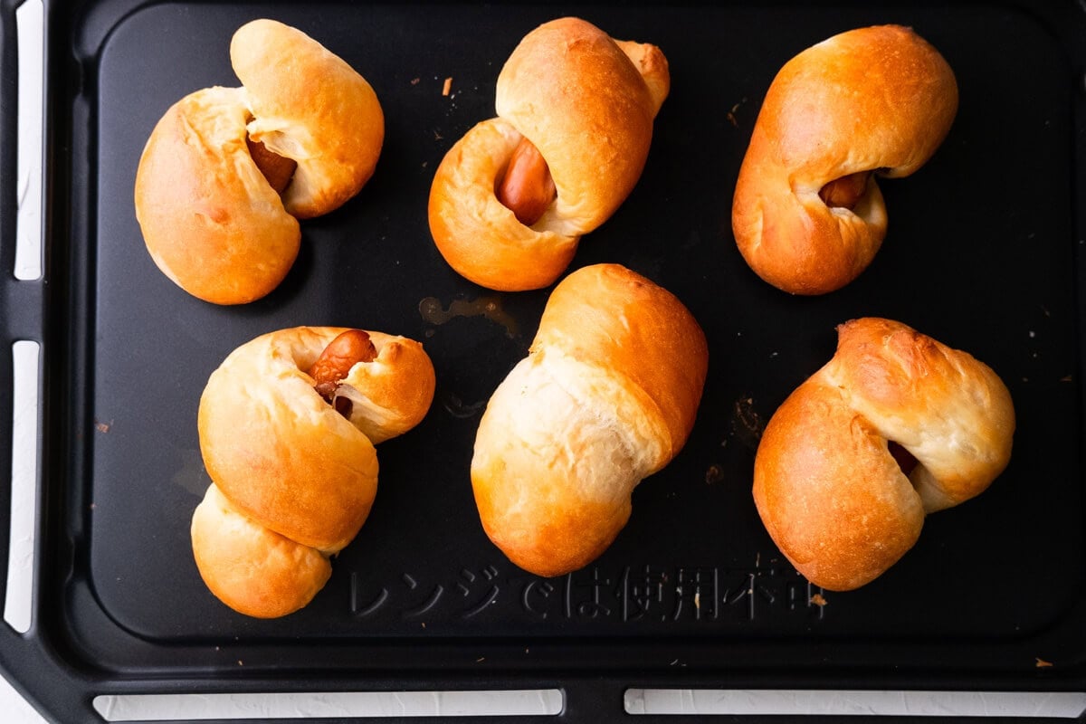 Baked sausage rolls on a baking sheet. 