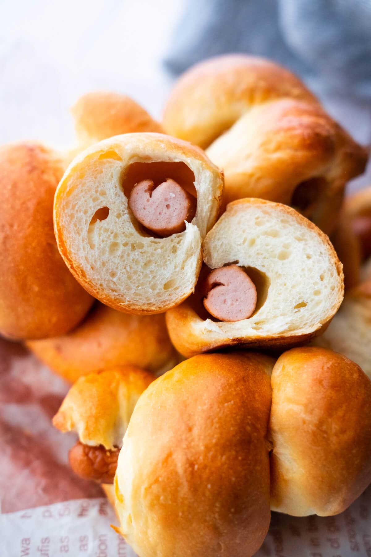 Homemade sausage roll cut in half, showing the fluffy interior and sausage filling.