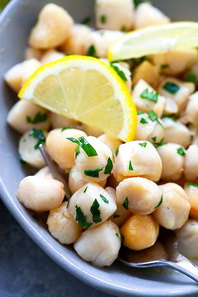 Pan-seared scallops with lemon butter sauce in a serving platter.