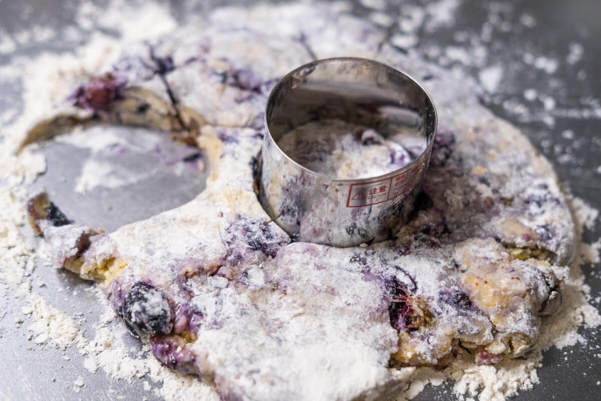 Cutting scones dough using a round cookie cutter. 