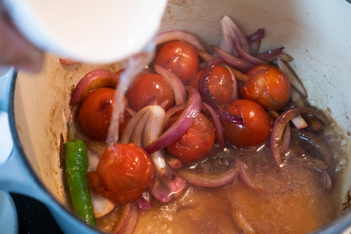 Add tamarind paste and the rice wash to the pot.