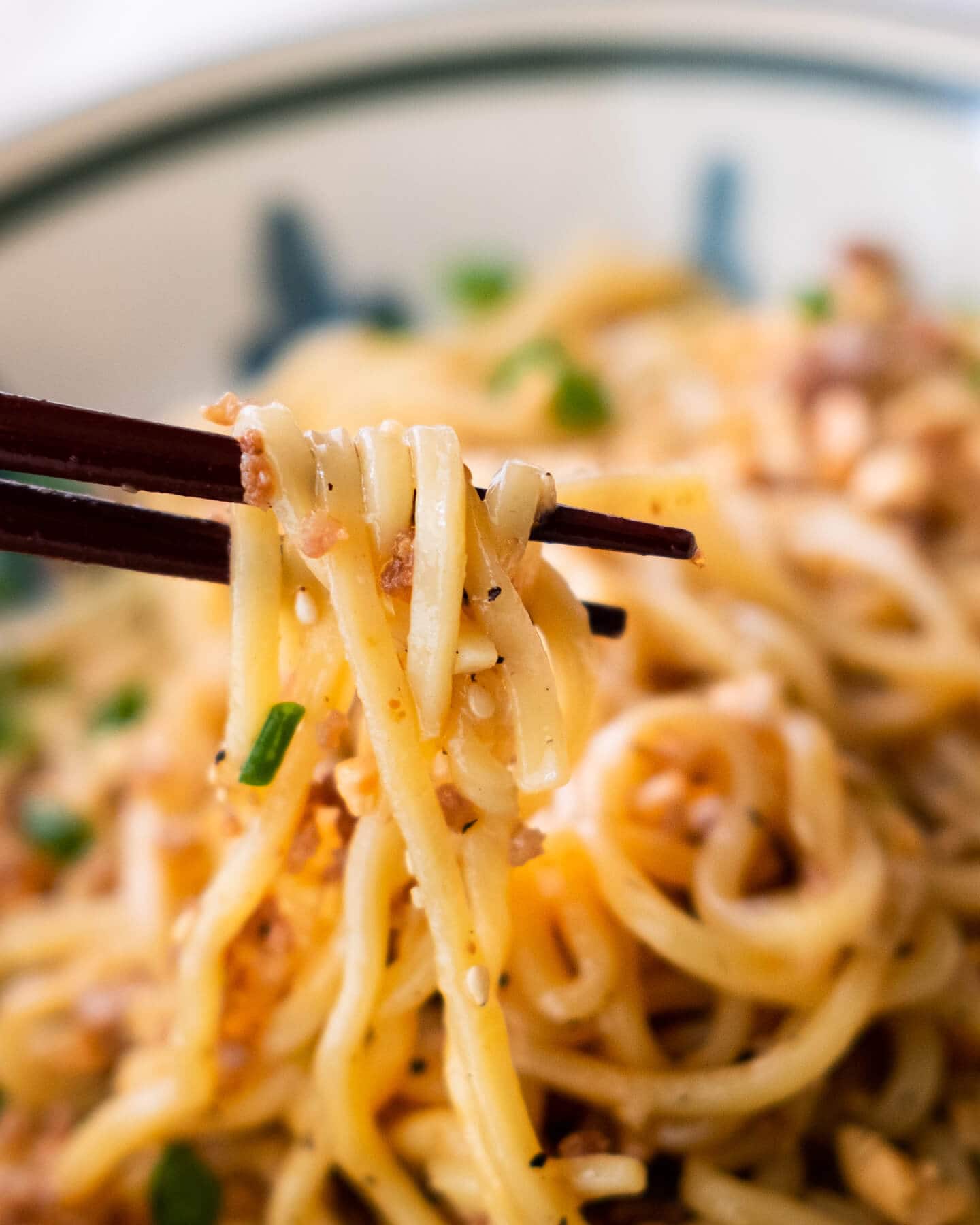 Szechuan Dan Dan Noodles picked with a pair of chopsticks.