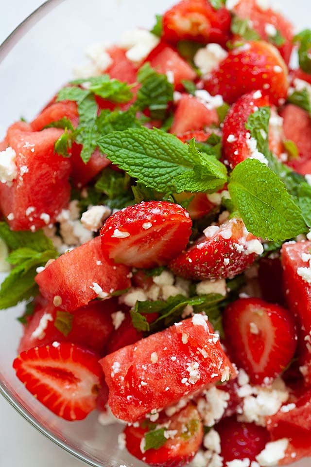 Watermelon feta salad with strawberries and mint leaves.