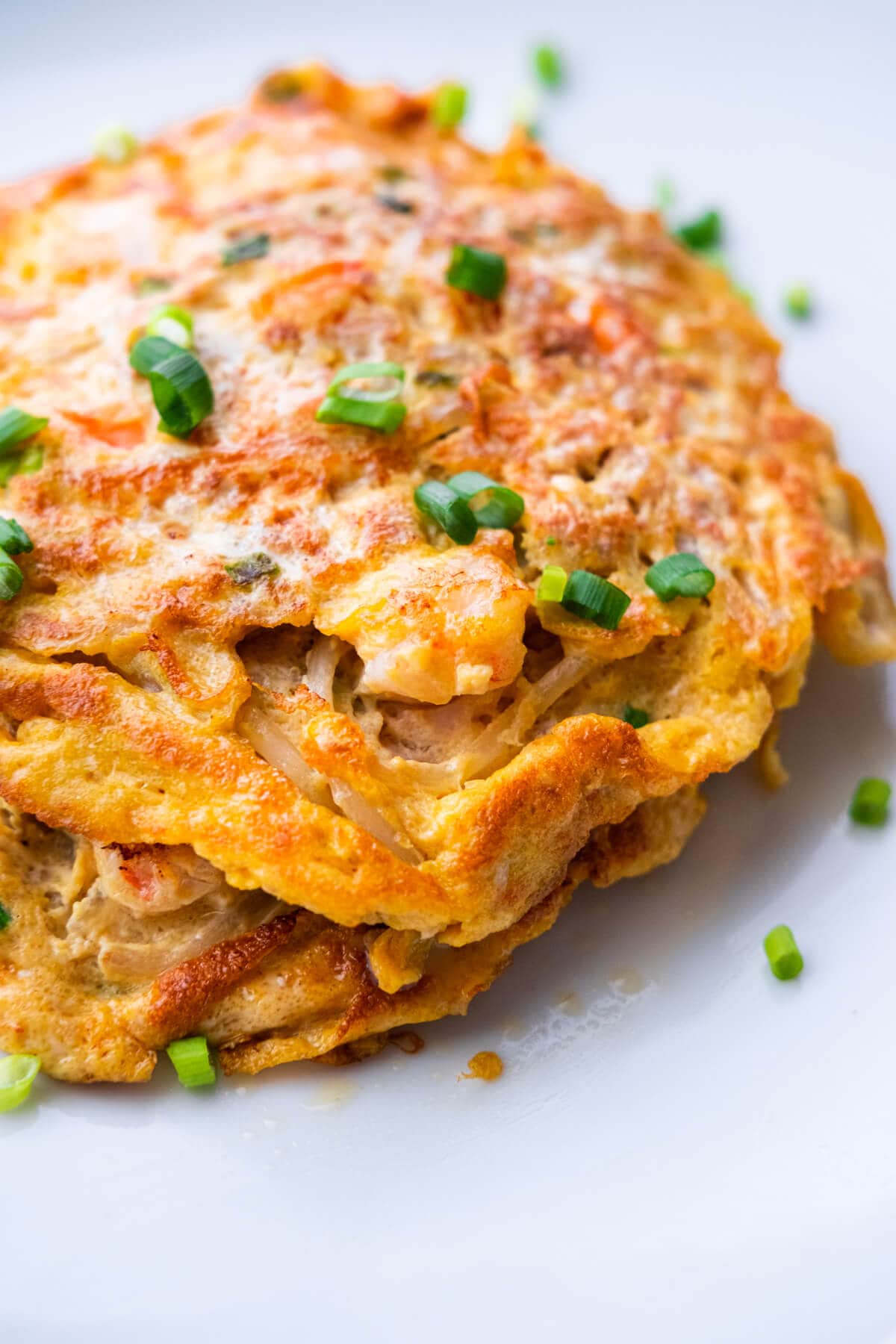 Egg foo young with shrimp, topped with chopped scallions. 