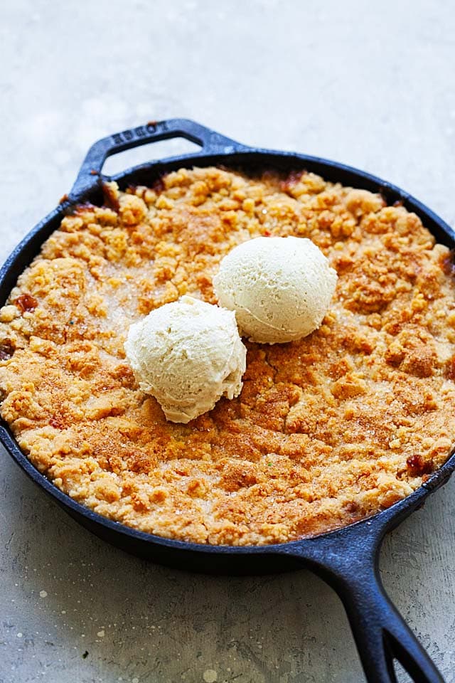 Easy peach cobbler topped with two scoops of ice cream.