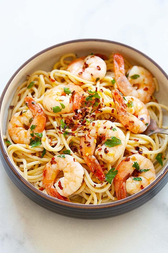 Easy shrimp spaghetti aglio e olio served with chopped parsley and red pepper flakes on top. 