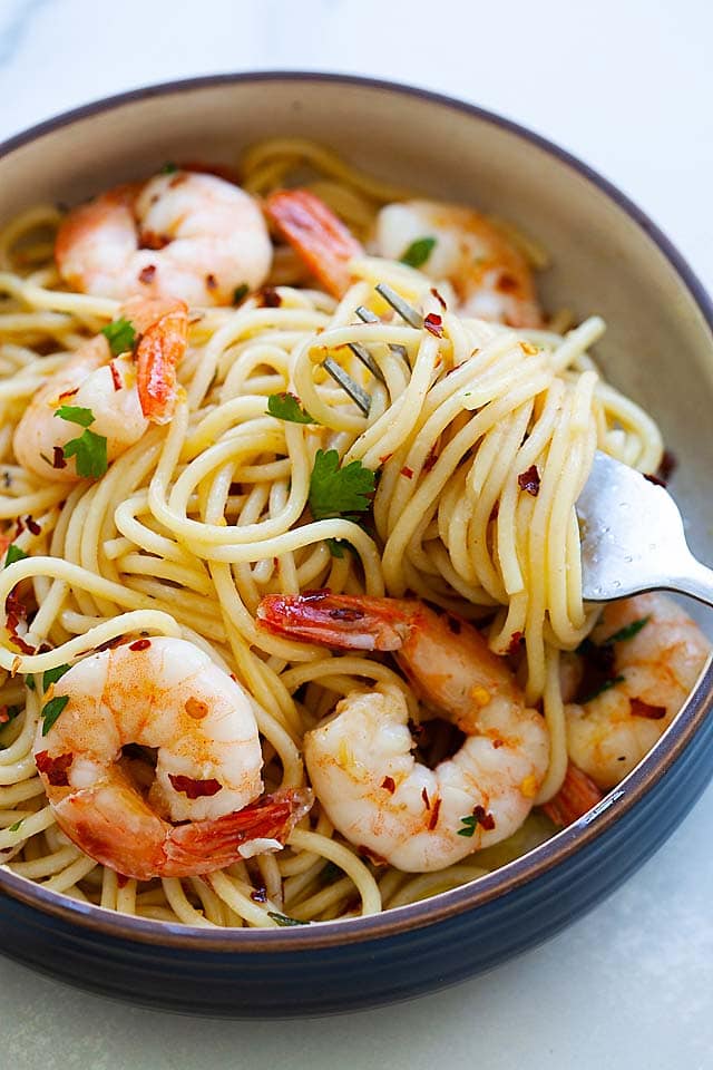 Pasta aglio e olio with shrimp, olive oil and garlic swirled on a fork. 