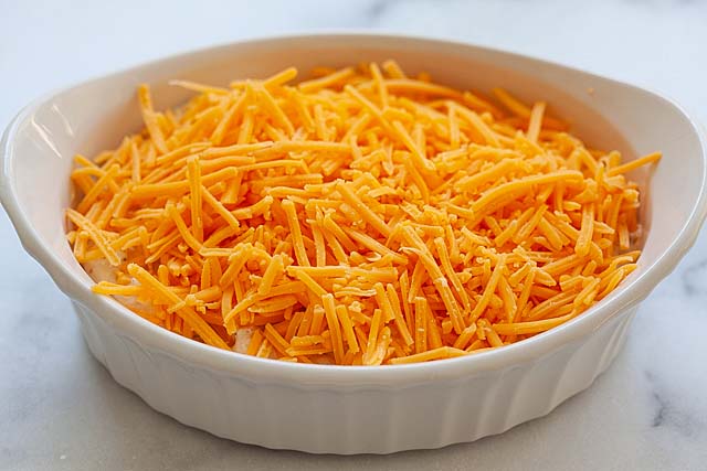 Crab dip with cheddar cheese on top in a baking dish.