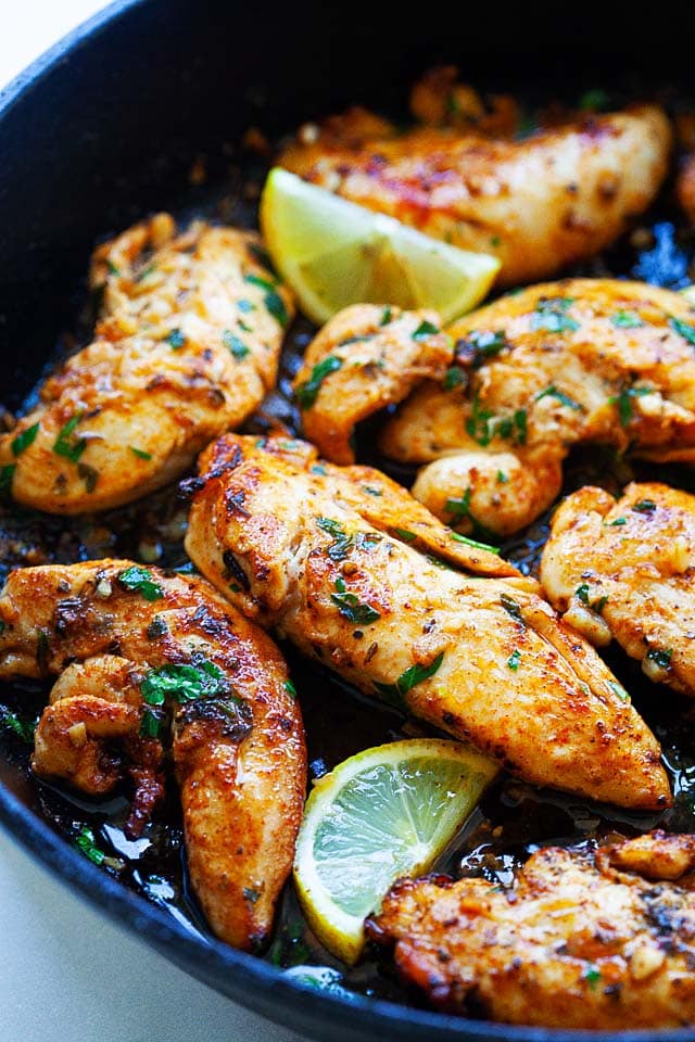 Close up picture of juicy chicken tenders on a skillet.