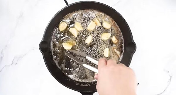 Add garlic cloves to the melted butter.