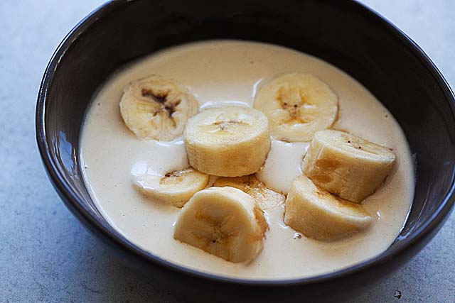 Banana pieces in bowl with frying batter.