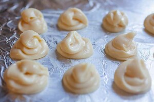 Chous pastry dough piped on a baking sheet.