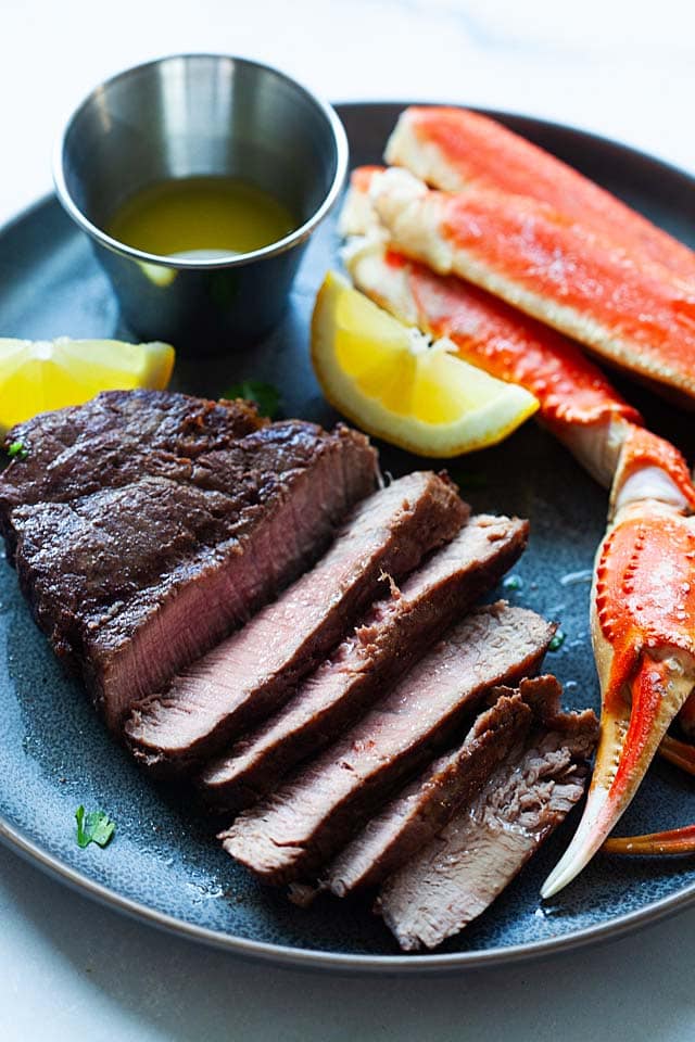 Surf and turf recipe with grilled steak and steamed crab legs.