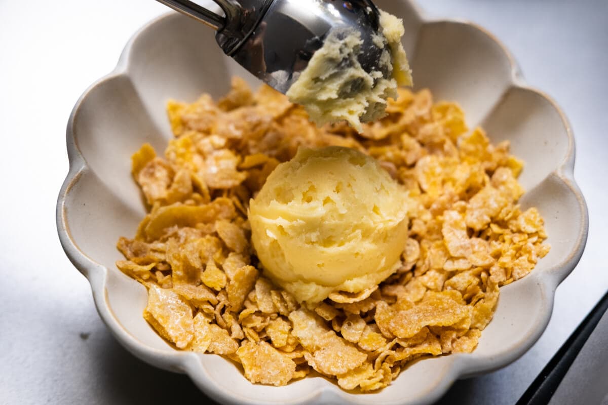 Roll each dough ball with the crushed cornflakes in a bowl. 