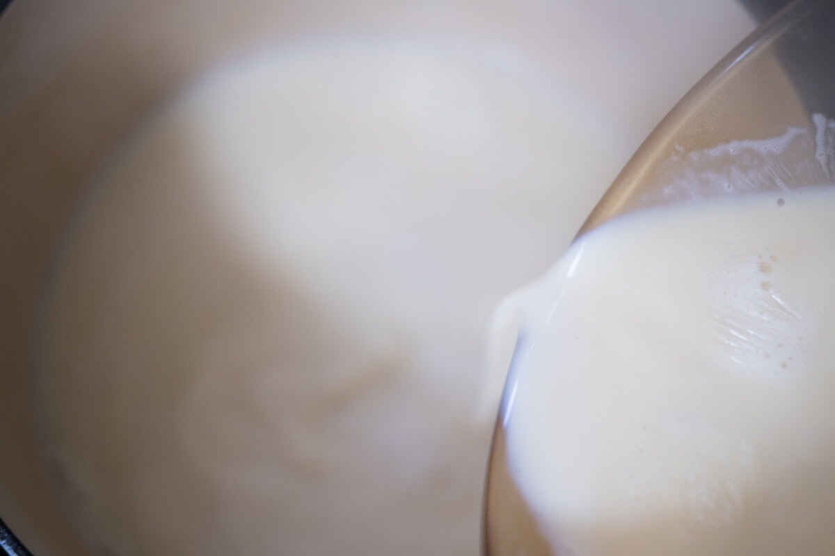 Add the gypsum mixture to a Dutch oven, then pour in the boiling soy milk.