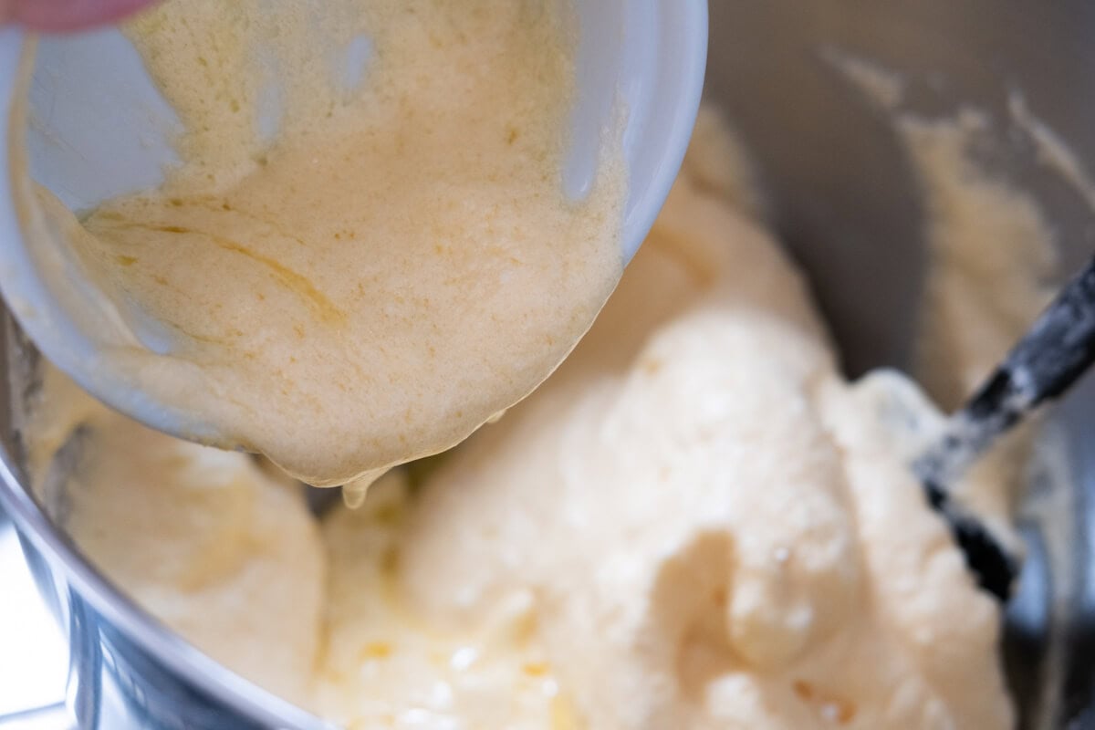 Adding melted butter to the batter and fold to combine well in a mixing bowl. 