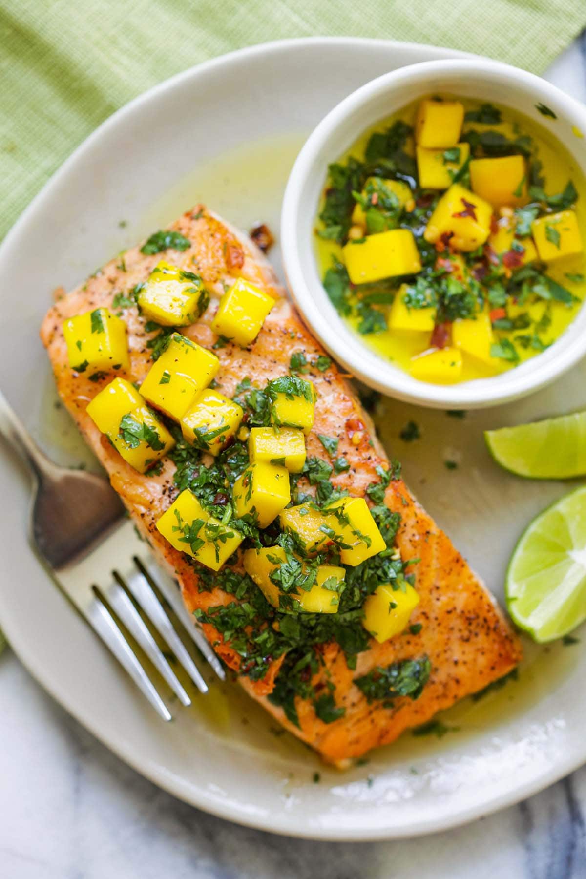 Easy and quick salmon covered with Chimichurri sauce with mango cubes and fresh parsley on top.