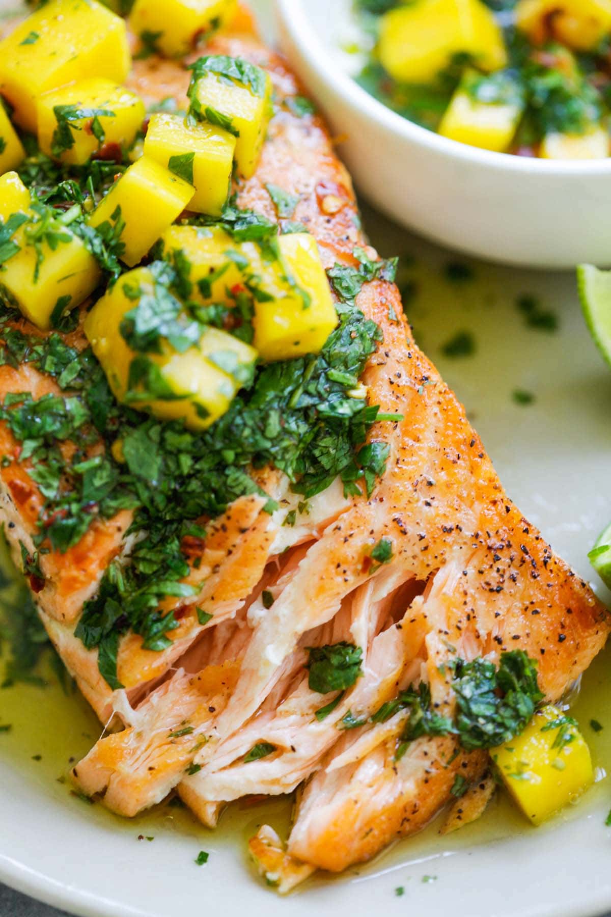 Chimichurri salmon dish with mango, elegantly presented and visually appealing. 