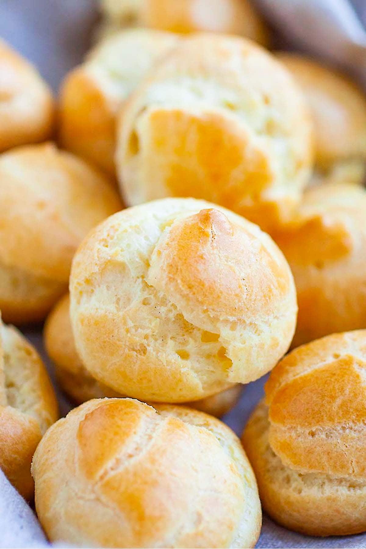 A delightful display of Easy French Choux Pastry Puffs, exhibiting their golden-brown exterior and airy, hollow interior.