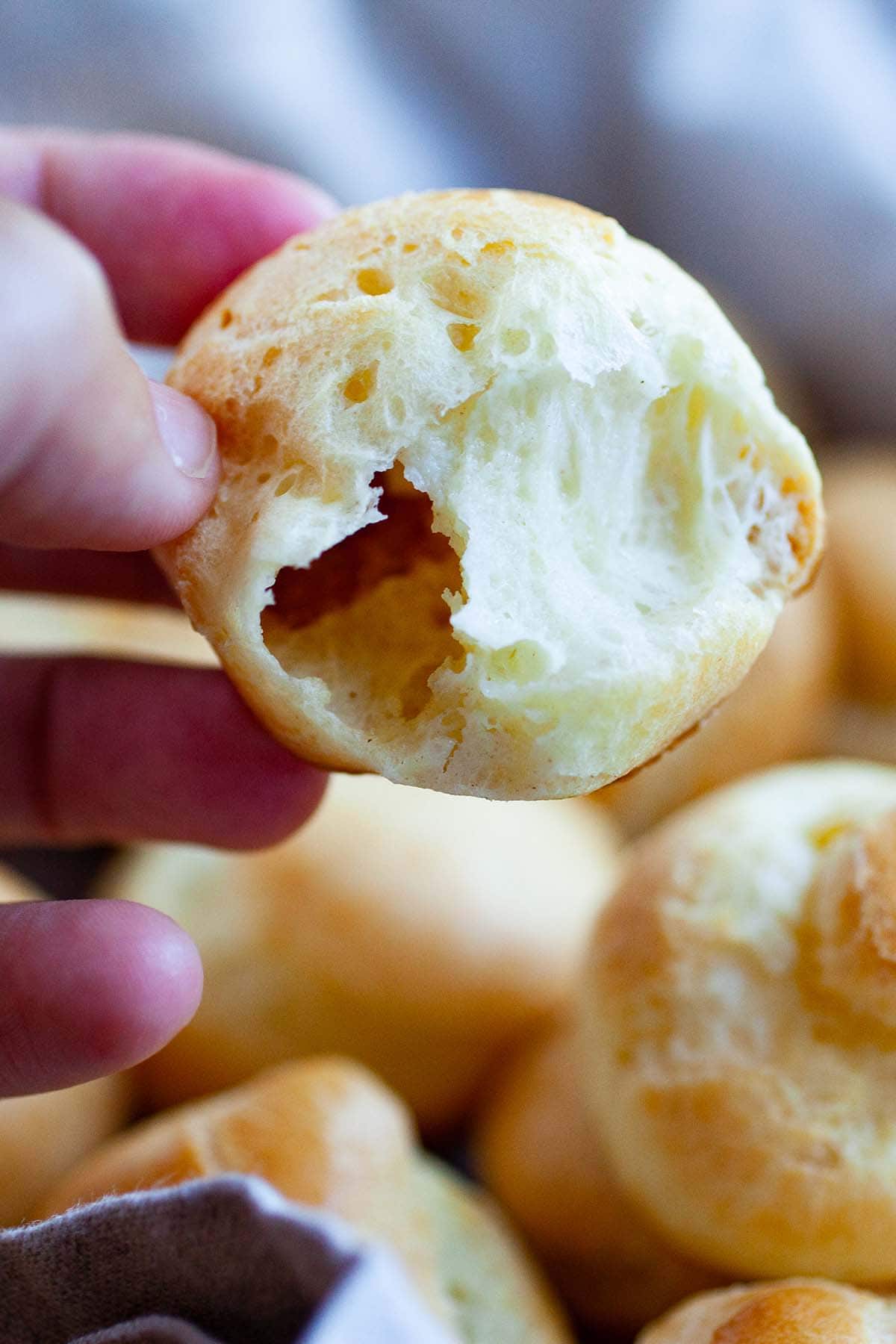 A half opened French Choux Pastry puff showcasing its delicate and cripsy shell encasing its soft and airy interior.