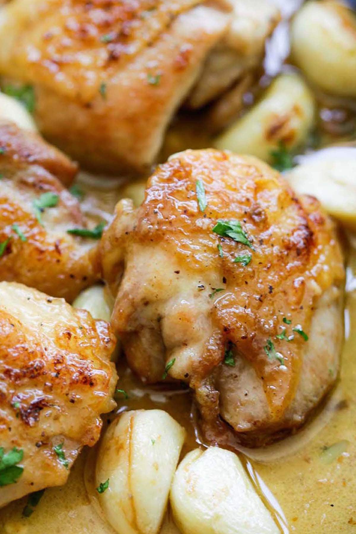 Creamy garlic chicken in a creamy sauce with garlic loves, cooked in a cast iron skillet.